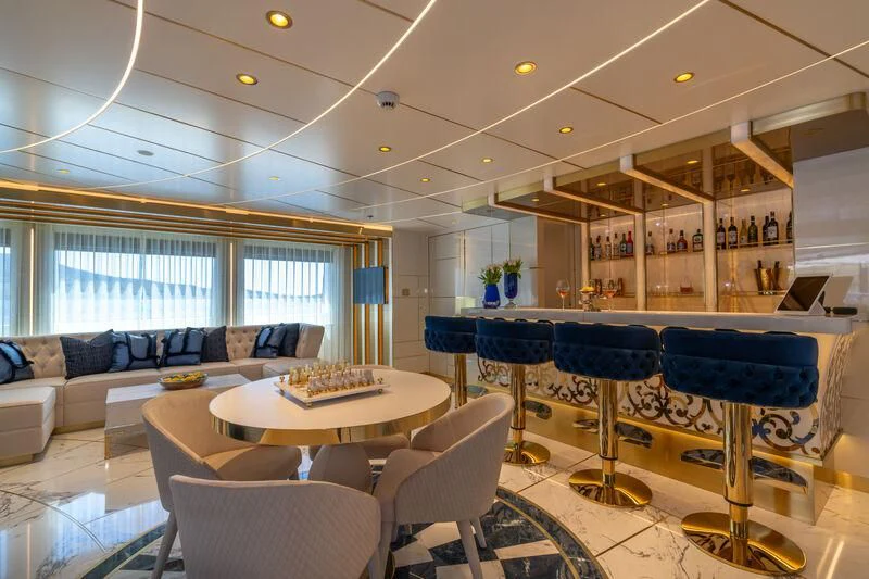 a room with a couch and a table and chairs aboard LEONA Yacht for Sale