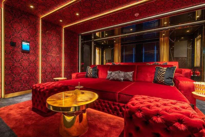a living room with a red couch aboard LEONA Yacht for Sale