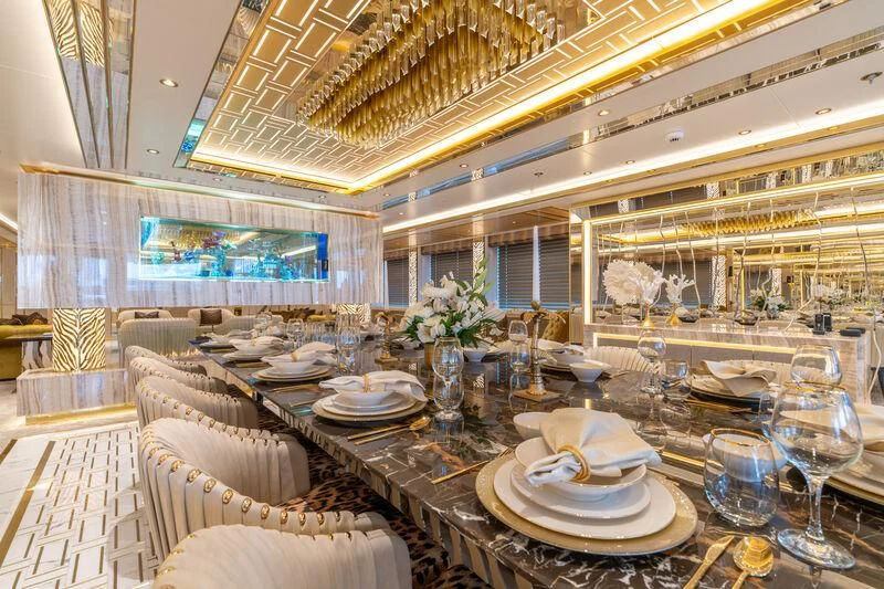 a large room with a table and chairs aboard LEONA Yacht for Sale