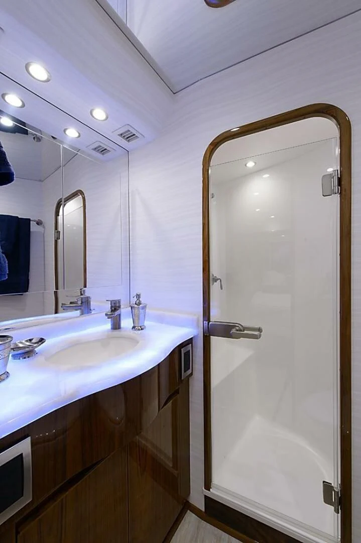 a bathroom with a glass shower door aboard INSTIGATOR Yacht for Sale