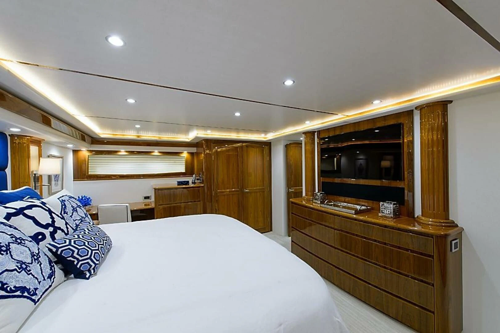 a bedroom with a bed and a dresser aboard INSTIGATOR Yacht for Sale