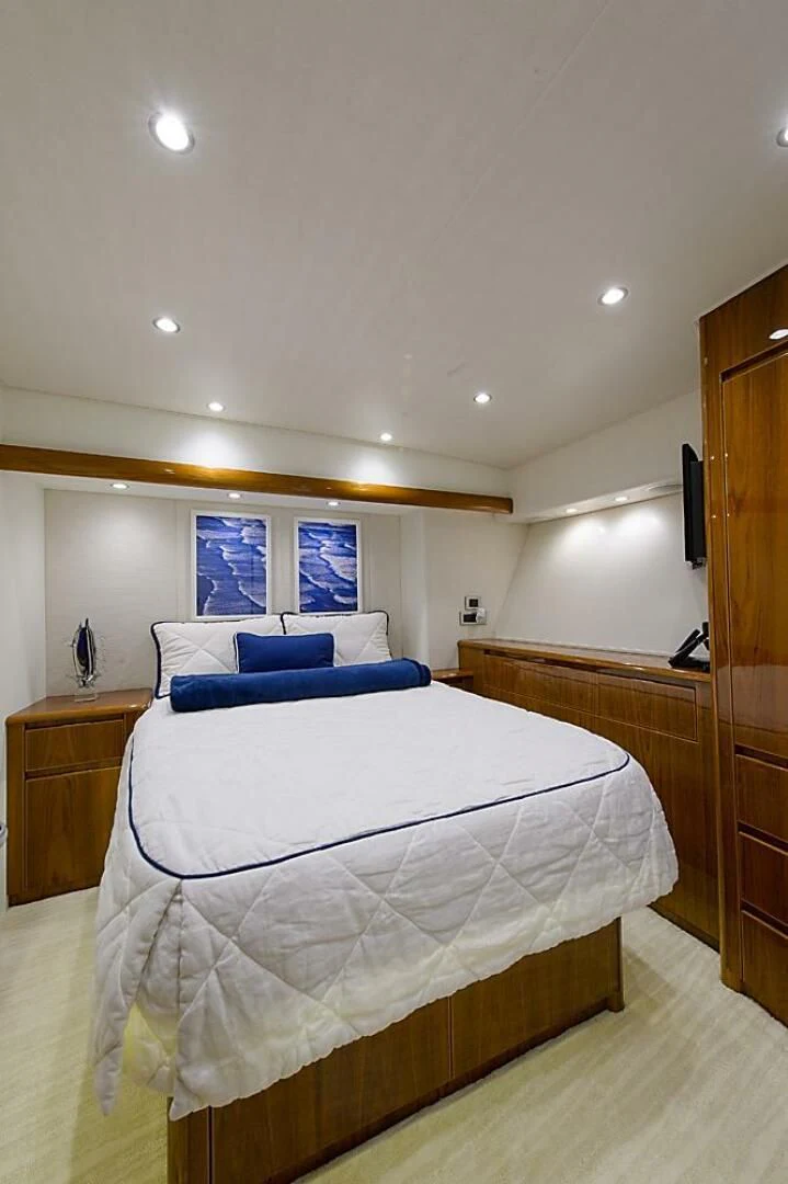 a bedroom with a bed and a blue couch aboard INSTIGATOR Yacht for Sale