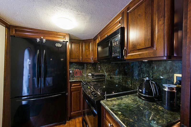 a kitchen with black appliances aboard CASABELLA Yacht for Sale