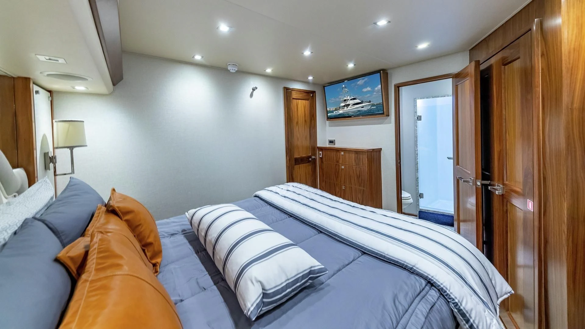 a bedroom with a bed and a wood cabinet aboard AUSSIE RULES Yacht for Sale
