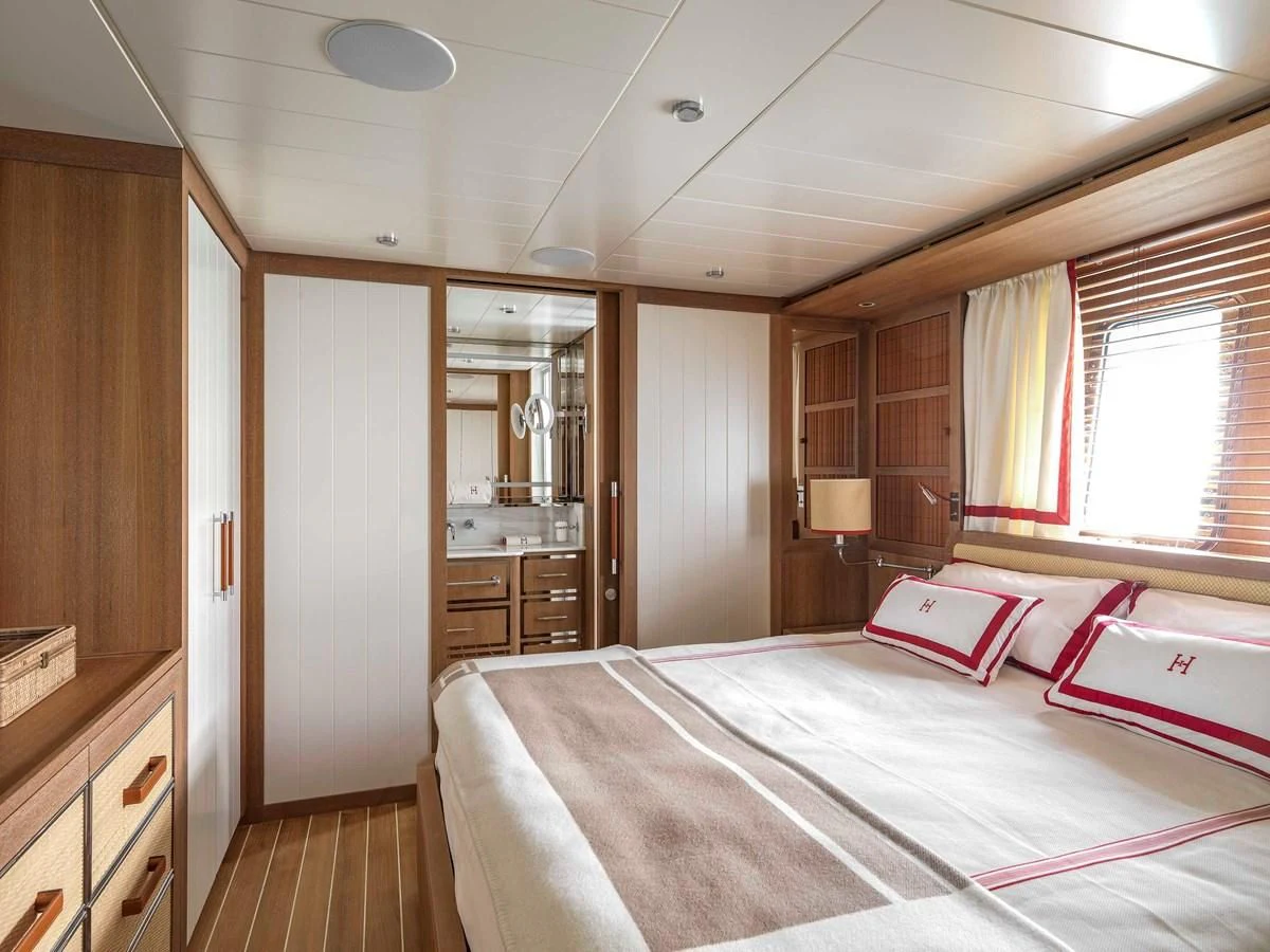 a bedroom with a bed and a mirror aboard PAIZA ONE Yacht for Sale