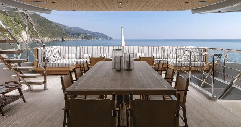 a table on a deck overlooking a body of water aboard PAIZA ONE Yacht for Sale