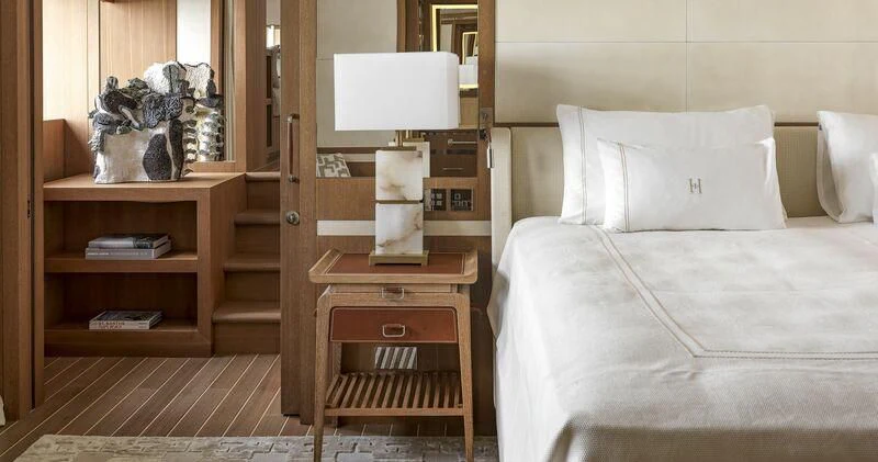 a room with a bed and a shelf with books on it aboard PAIZA ONE Yacht for Sale