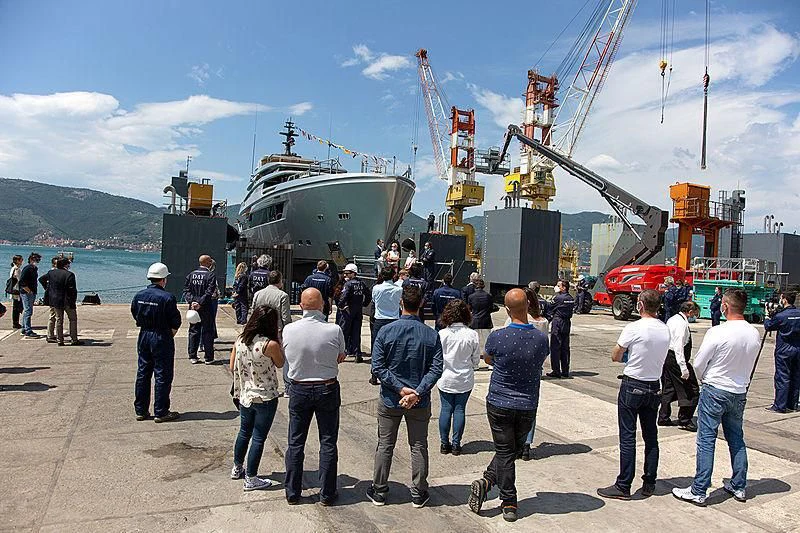 a group of people standing next to a helicopter aboard PAIZA ONE Yacht for Sale