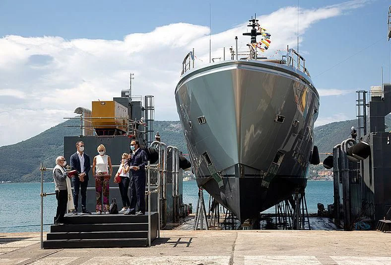 a group of people standing on a platform next to a large ship aboard PAIZA ONE Yacht for Sale