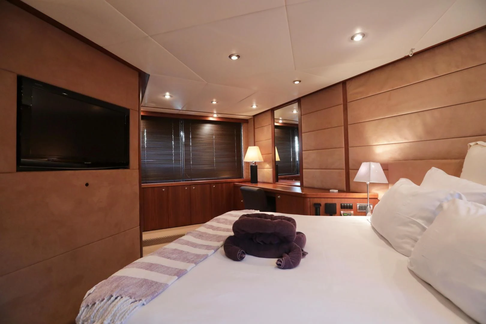 a hotel room with a bed and tv aboard CAPRICHO II Yacht for Sale