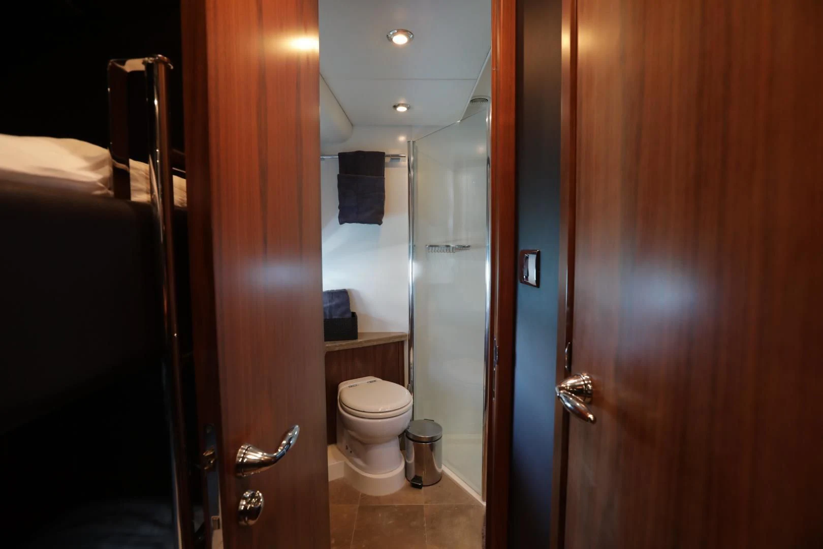 a bathroom with a toilet and a door aboard CAPRICHO II Yacht for Sale