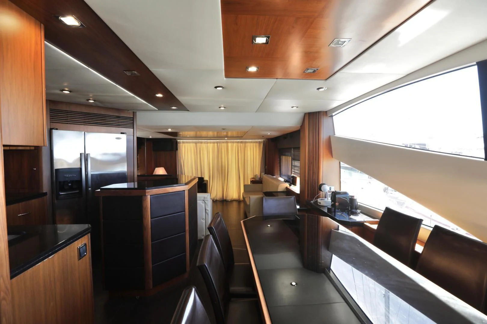 a room with a large window and a desk with chairs aboard CAPRICHO II Yacht for Sale