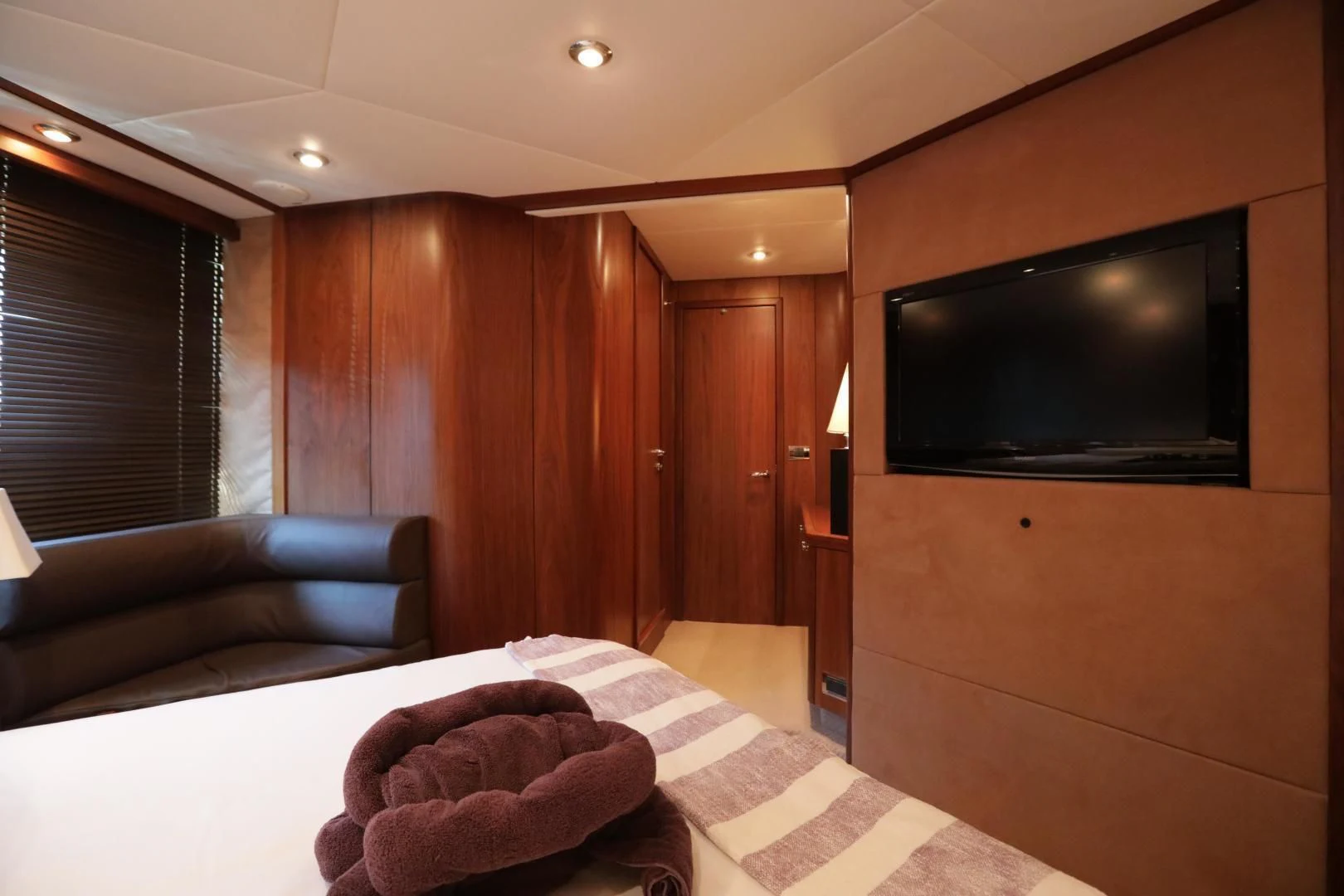 a living room with a tv and couches aboard CAPRICHO II Yacht for Sale