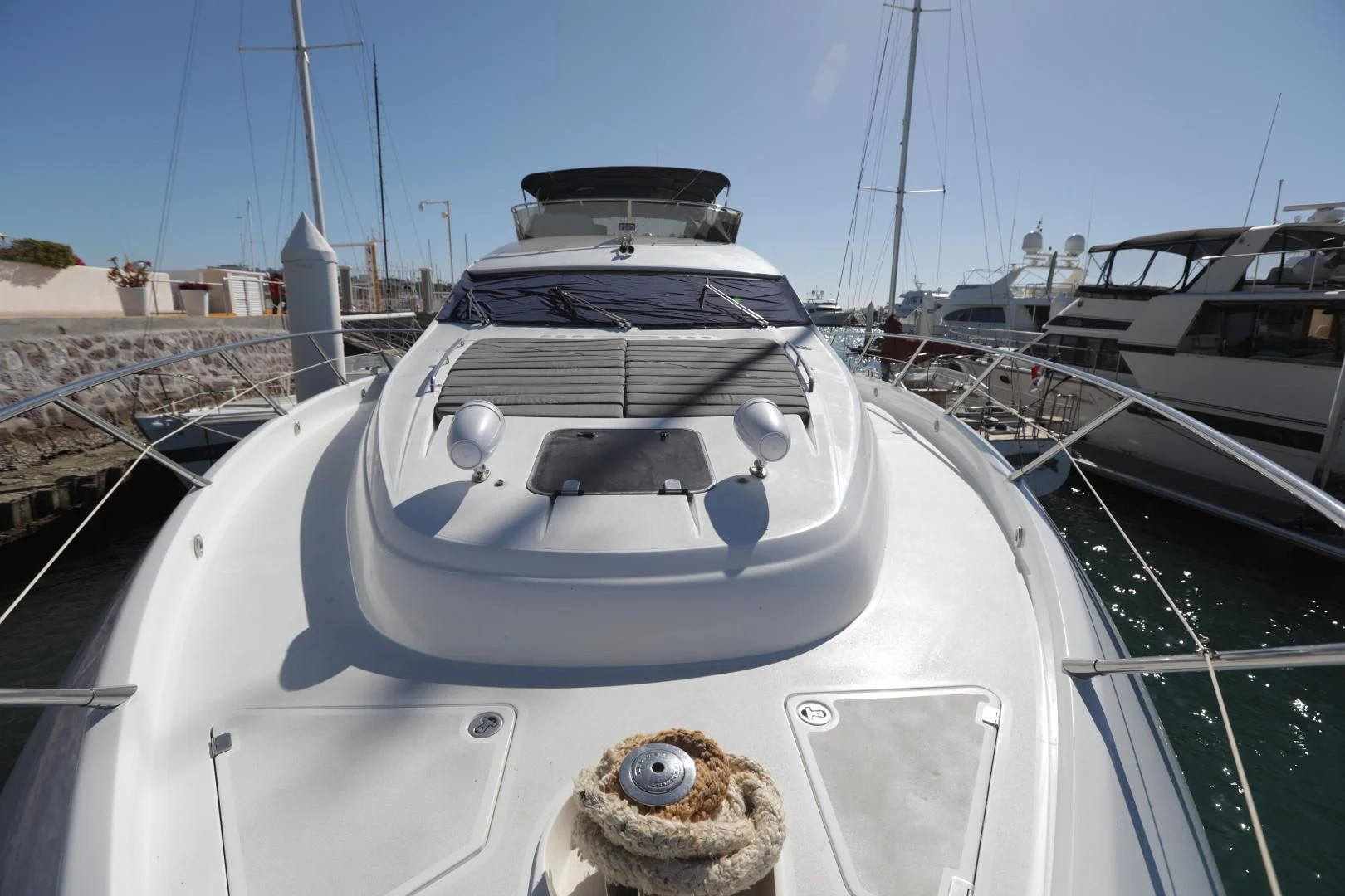 a white yacht in a harbor aboard CAPRICHO II Yacht for Sale
