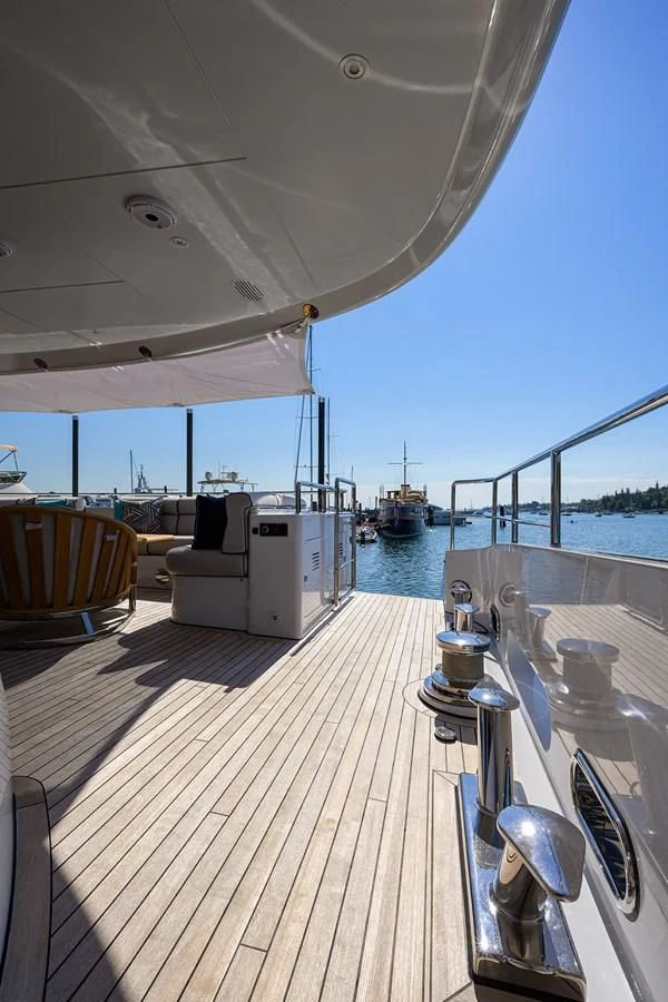 a deck with a large boat in the background aboard SHARKFINN Yacht for Sale