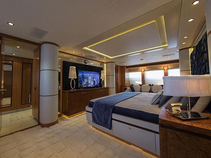 a bedroom with a bed and a tv aboard SHARKFINN Yacht for Sale