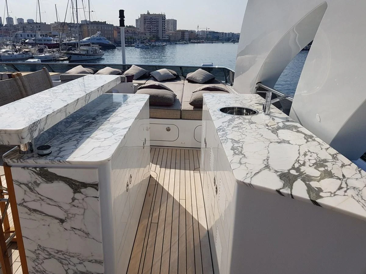 a large white building with a large roof and a body of water in the background aboard SHARKFINN Yacht for Sale