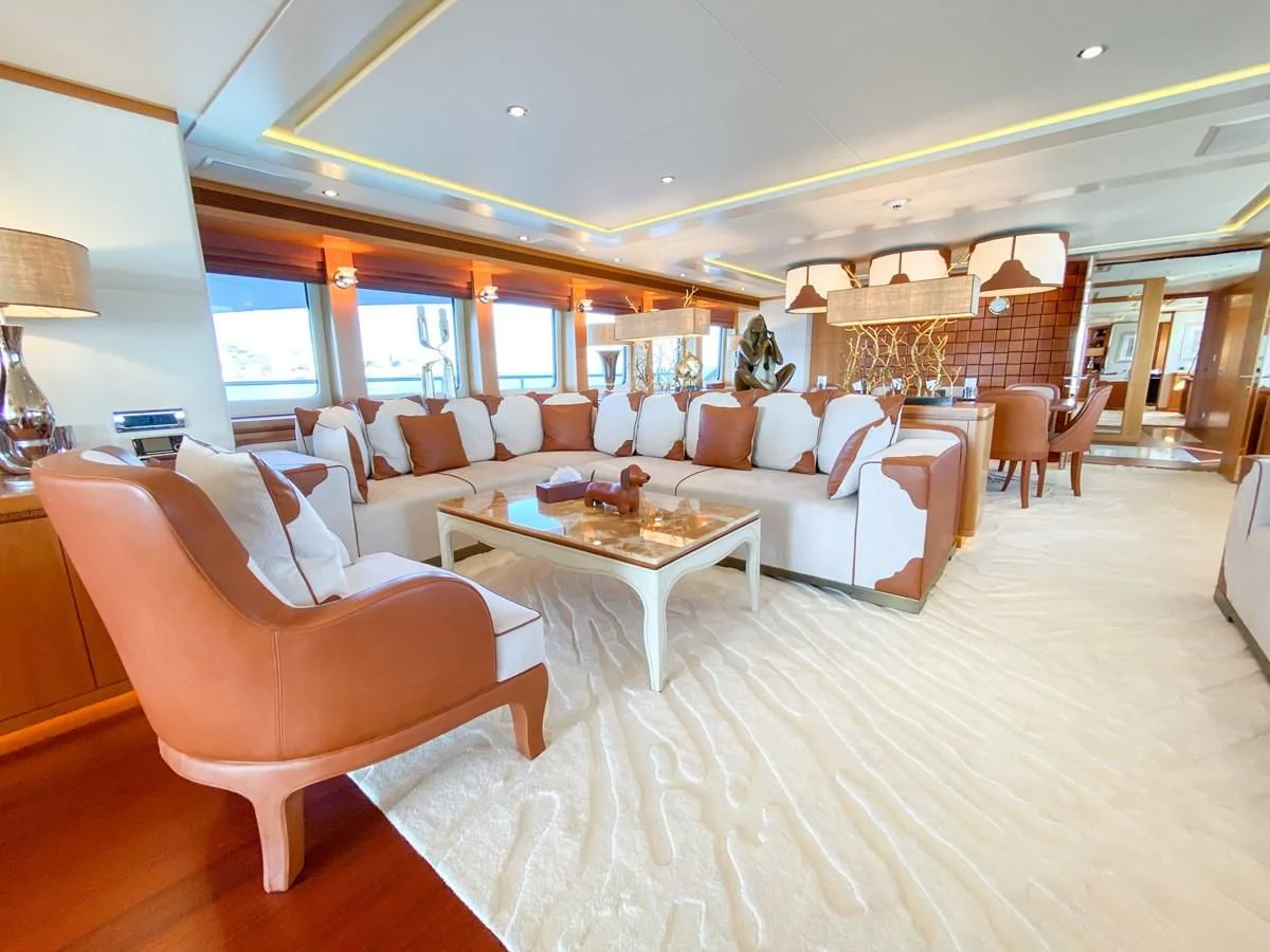 a living room with a large white couch and a table aboard SHARKFINN Yacht for Sale