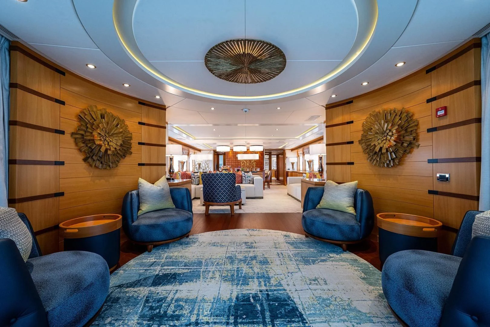 a large room with a large blue rug and a large chandelier aboard SHARKFINN Yacht for Sale