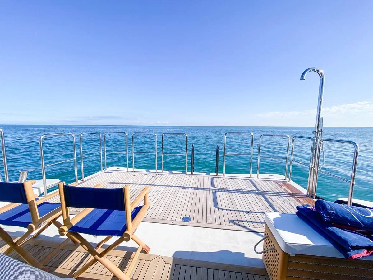 a deck with chairs on it by the water aboard SHARKFINN Yacht for Sale
