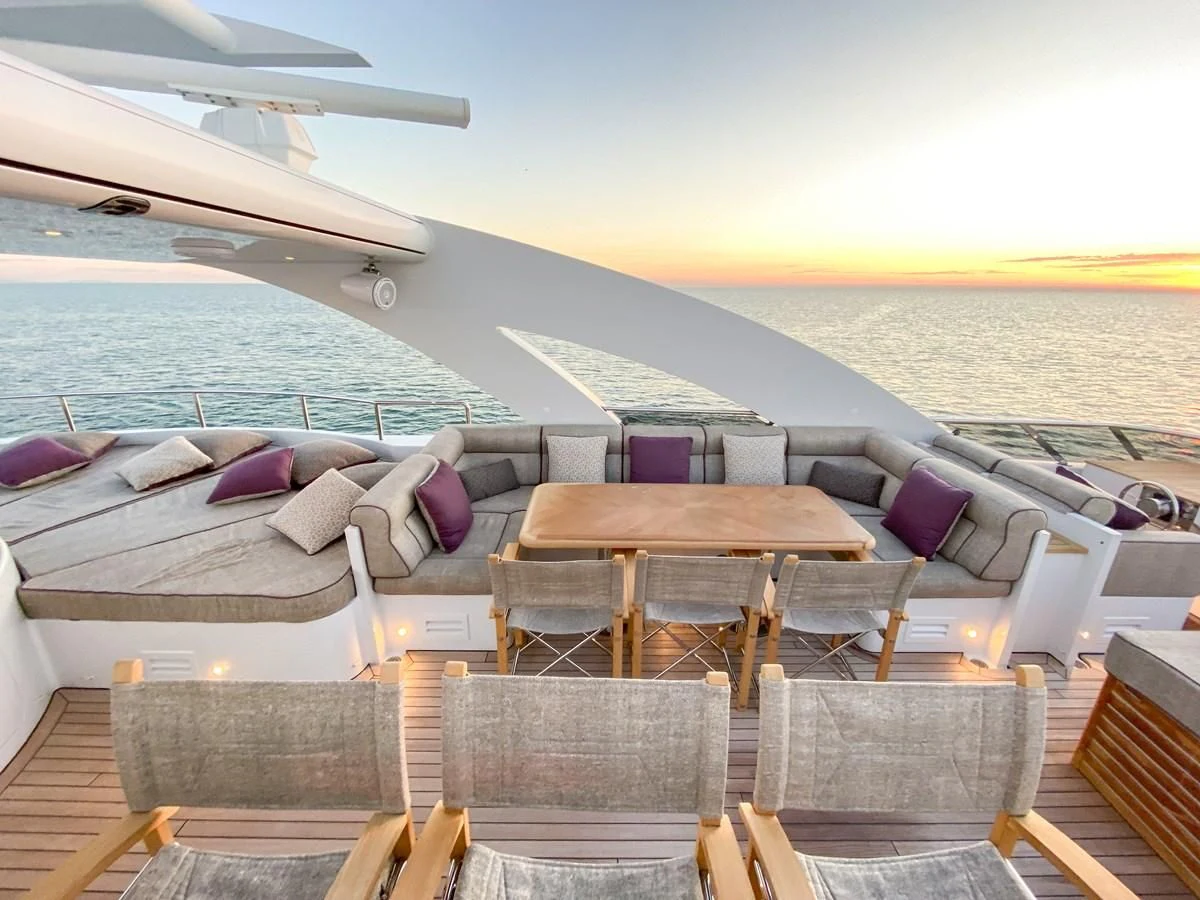 a deck with chairs and a table on it aboard SHARKFINN Yacht for Sale