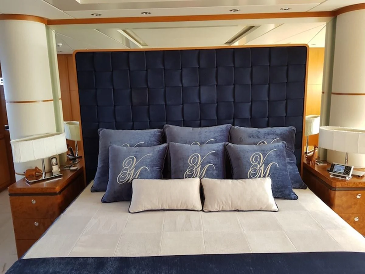a bed with blue pillows aboard SHARKFINN Yacht for Sale