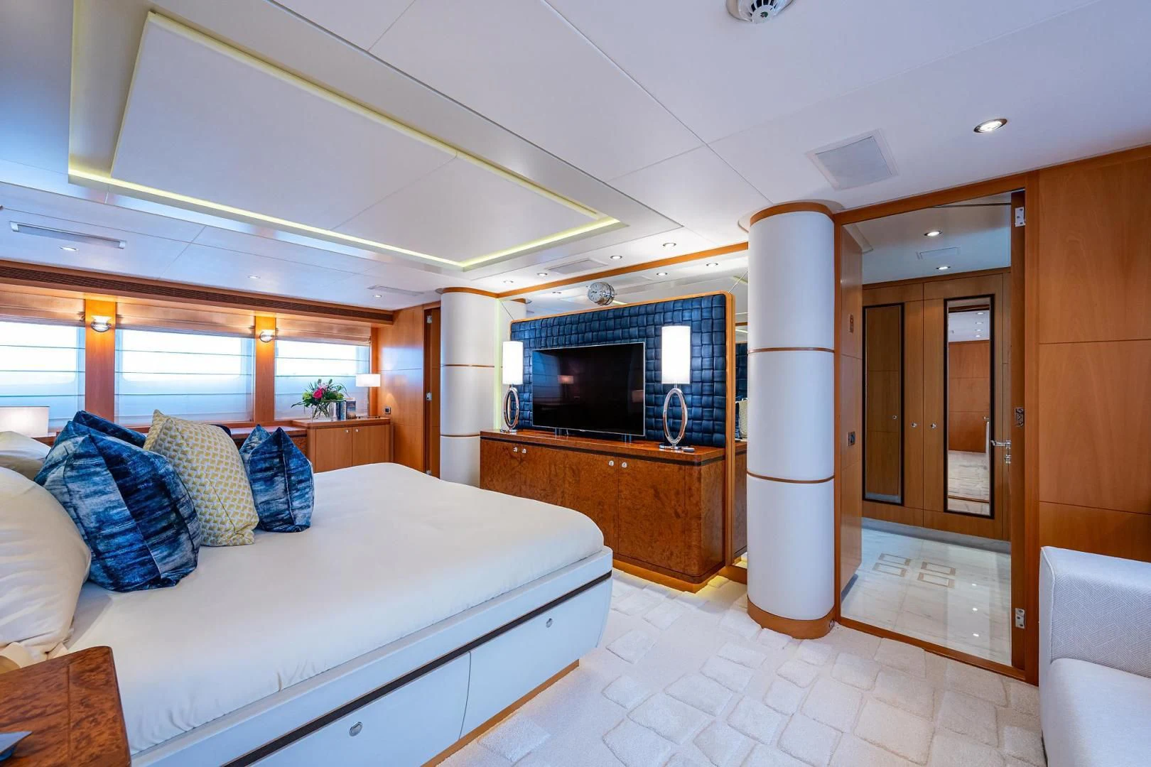 a bedroom with a bed and a fireplace aboard SHARKFINN Yacht for Sale