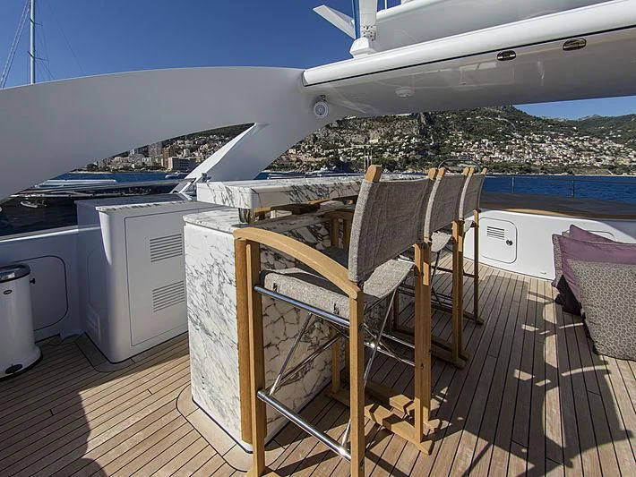 a deck with a chair and a table on it aboard SHARKFINN Yacht for Sale