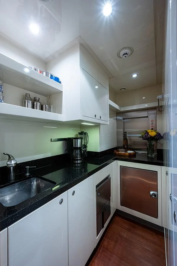 a kitchen with black counter tops aboard SHARKFINN Yacht for Sale