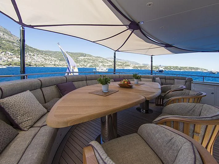 a table and chairs on a patio aboard SHARKFINN Yacht for Sale