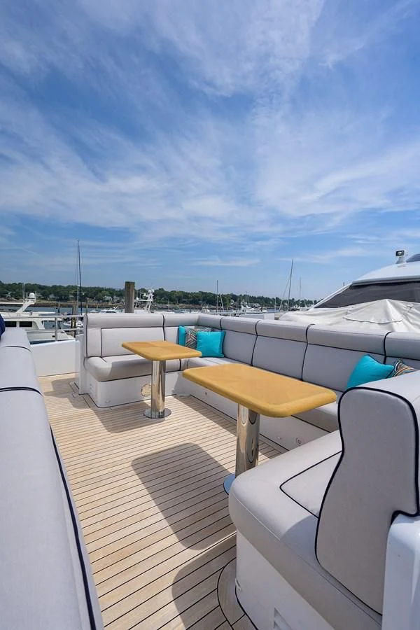 a deck with a table and chairs on it aboard SHARKFINN Yacht for Sale