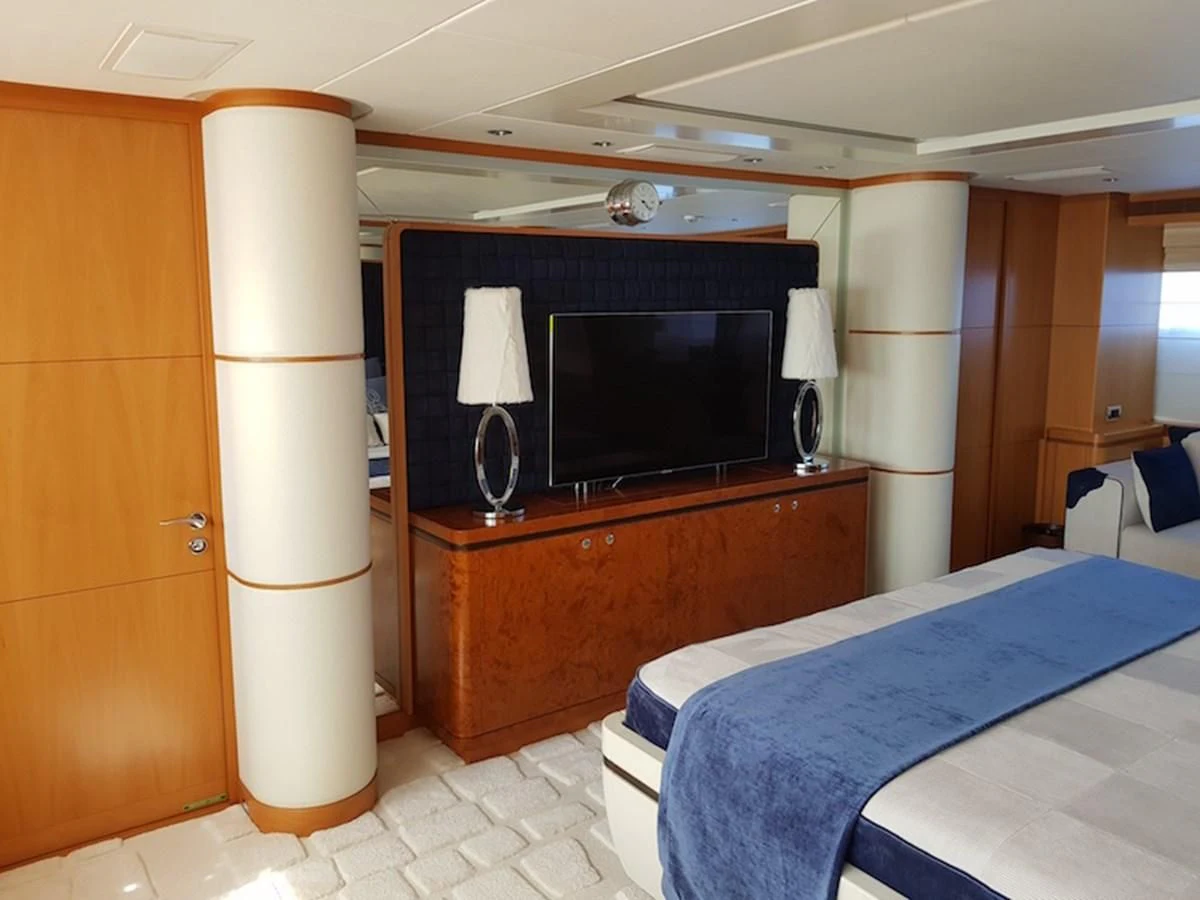 a bedroom with a bed and a television aboard SHARKFINN Yacht for Sale