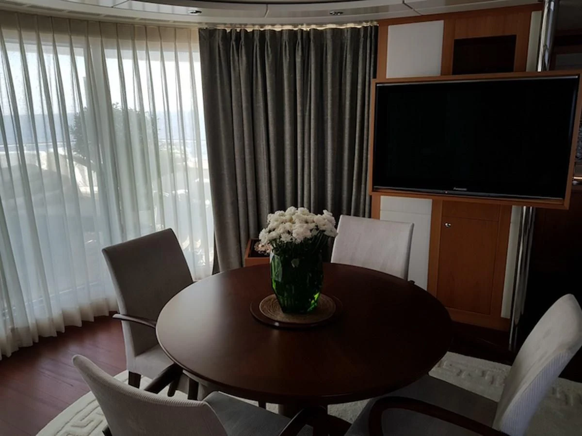 a table with chairs and a television aboard SHARKFINN Yacht for Sale