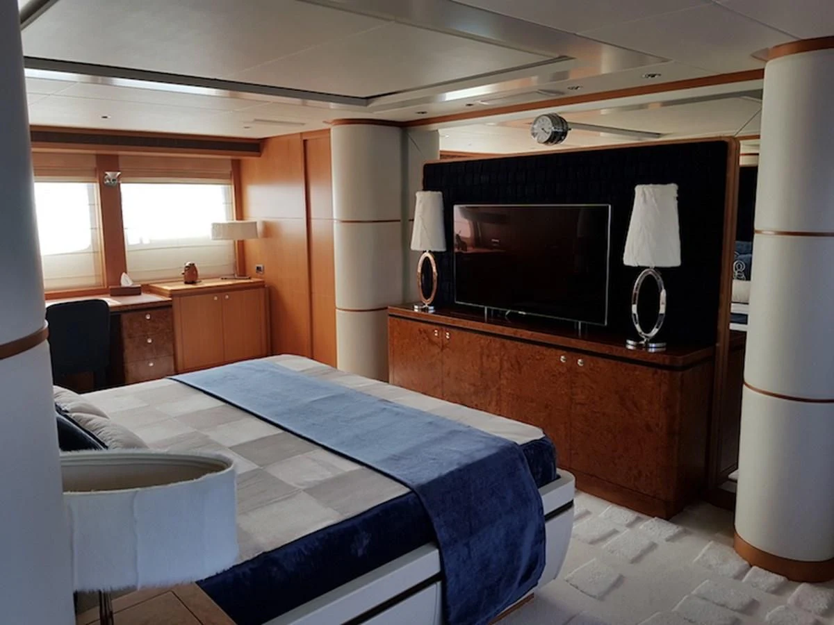 a bedroom with a television and a bed aboard SHARKFINN Yacht for Sale