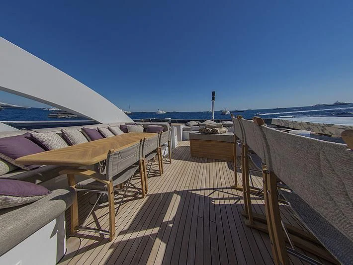 a deck with chairs and a body of water in the background aboard SHARKFINN Yacht for Sale