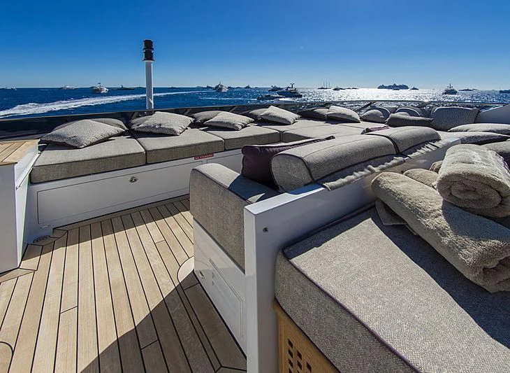 a deck with large rocks and a body of water in the background aboard SHARKFINN Yacht for Sale
