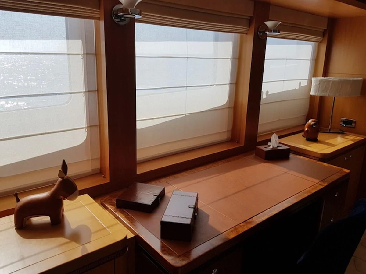 a desk with a lamp and a window aboard SHARKFINN Yacht for Sale