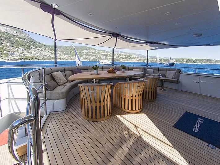 a deck with a table and chairs aboard SHARKFINN Yacht for Sale