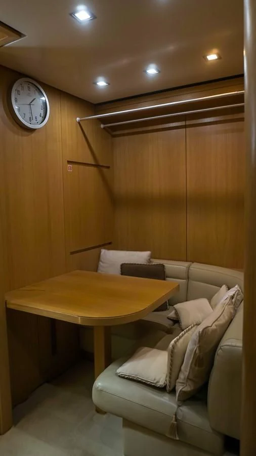 a room with a couch and a table and a clock aboard PETRUS Yacht for Sale