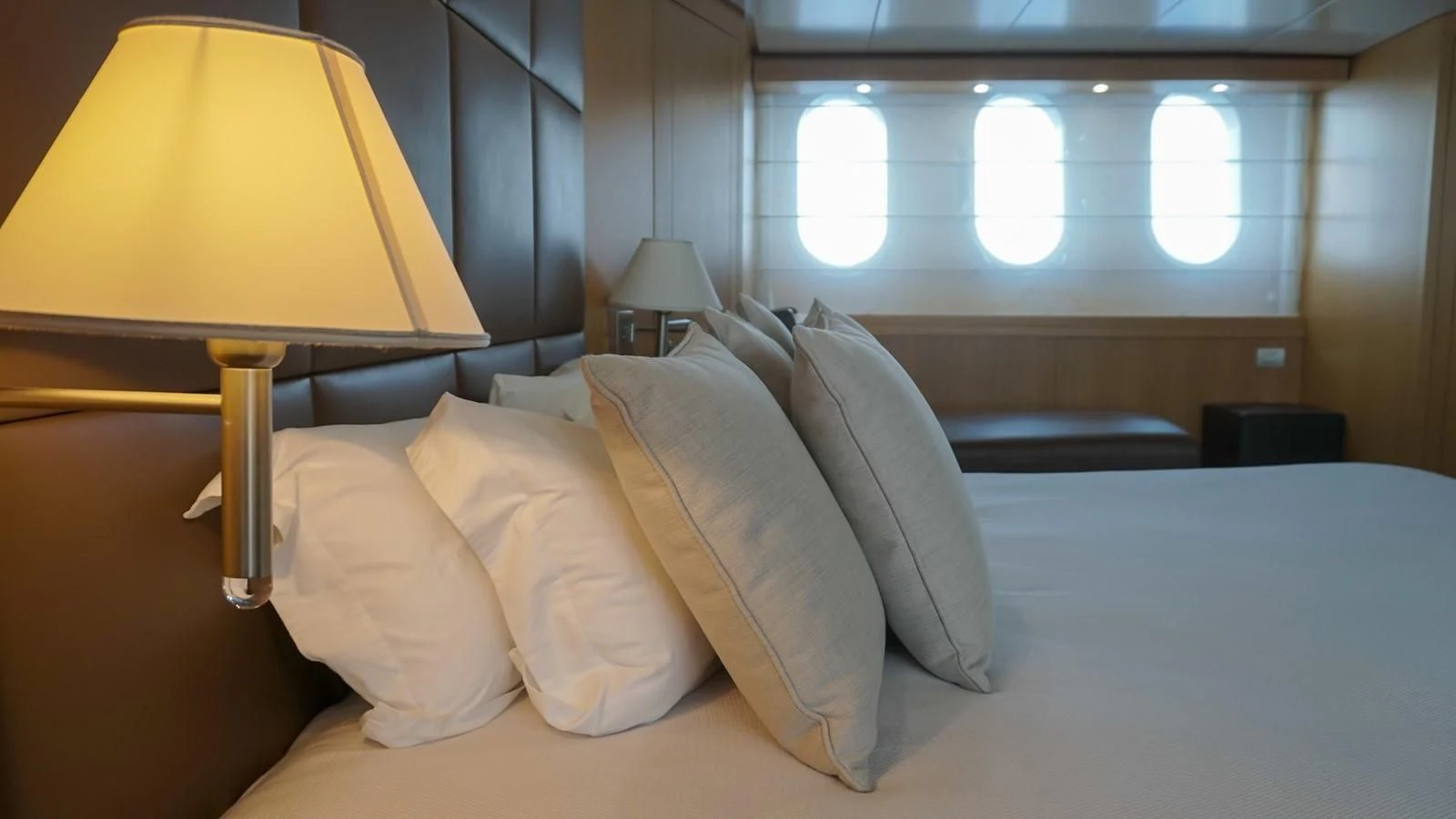 a bed with pillows and a lamp aboard PETRUS Yacht for Sale