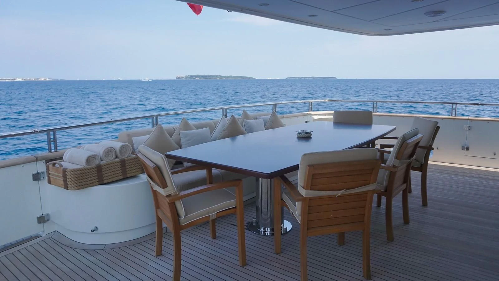 a table and chairs on a deck overlooking the ocean aboard PETRUS Yacht for Sale