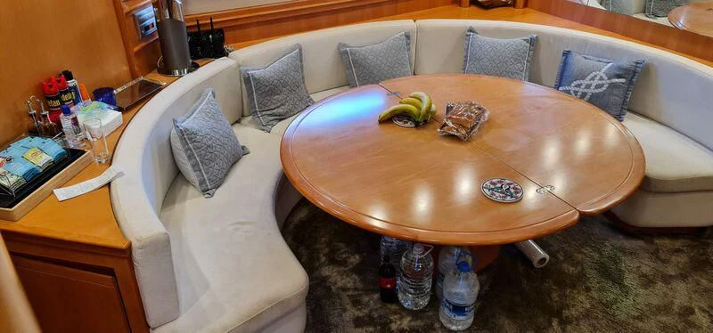 a couch with a round table and a coffee table with a white pillow aboard CELINE Yacht for Sale