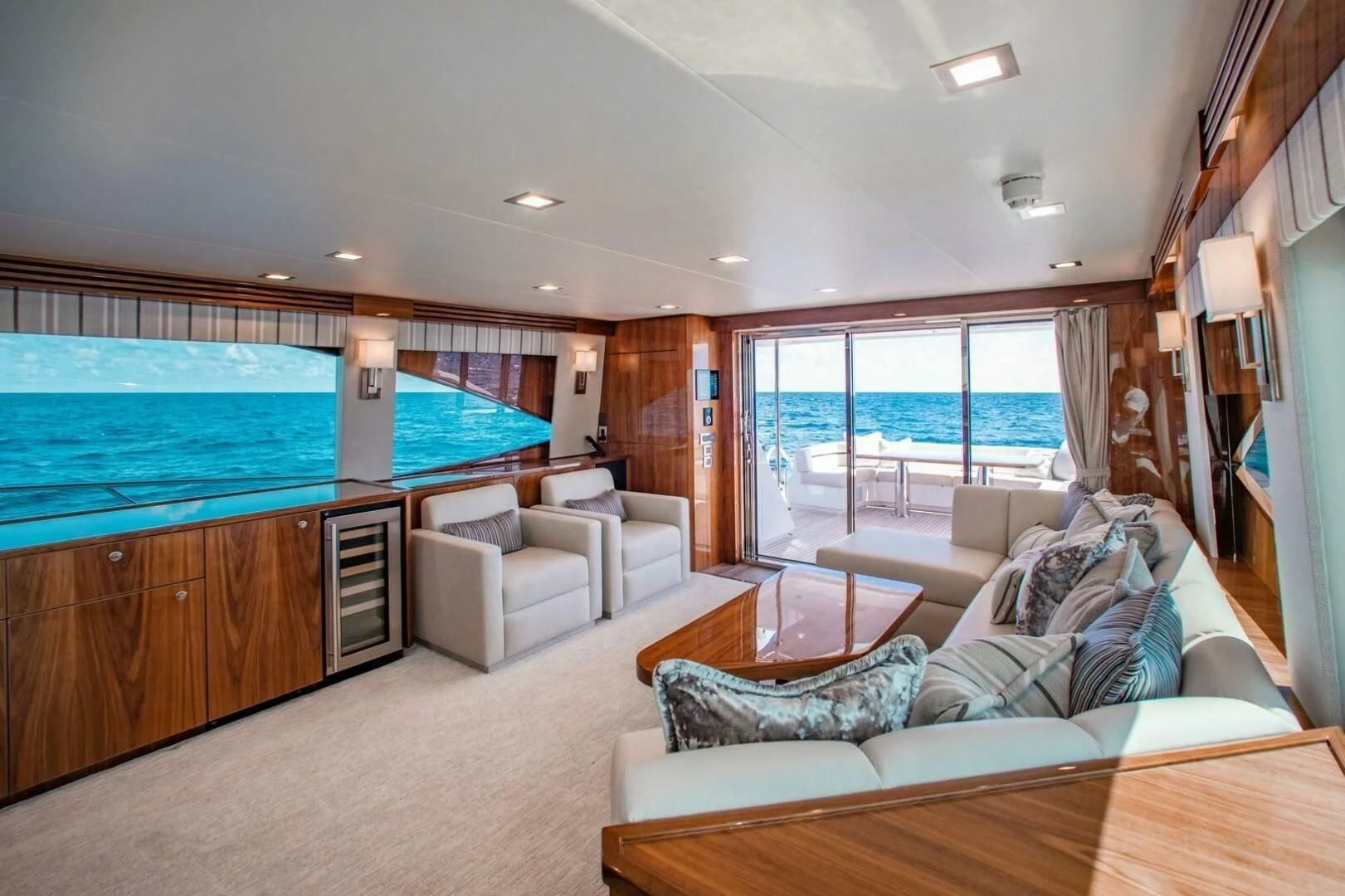 a living room with a large blue pool table and a large blue swimming pool aboard MANA Yacht for Sale