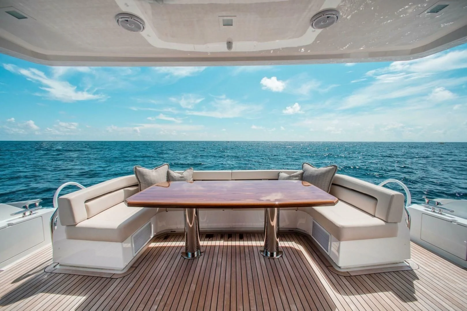 a table and chairs on a deck overlooking a large body of water aboard MANA Yacht for Sale