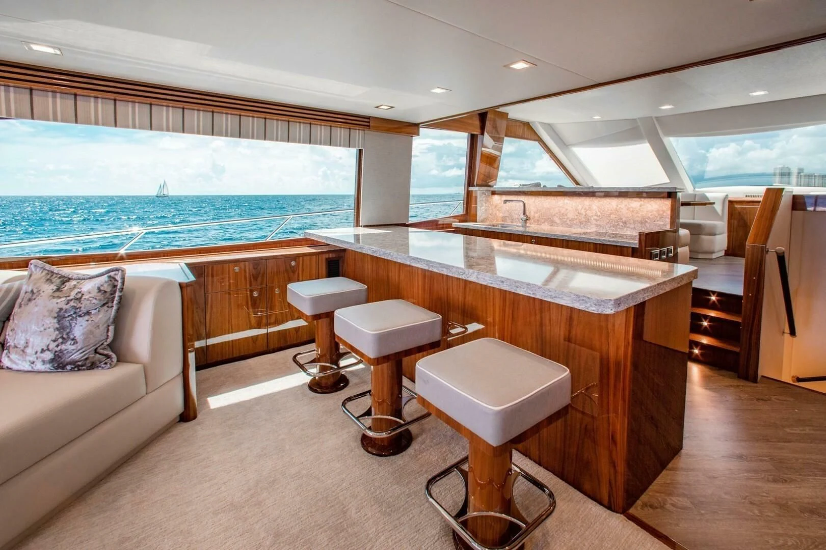 a room with a table and stools and a large window aboard MANA Yacht for Sale