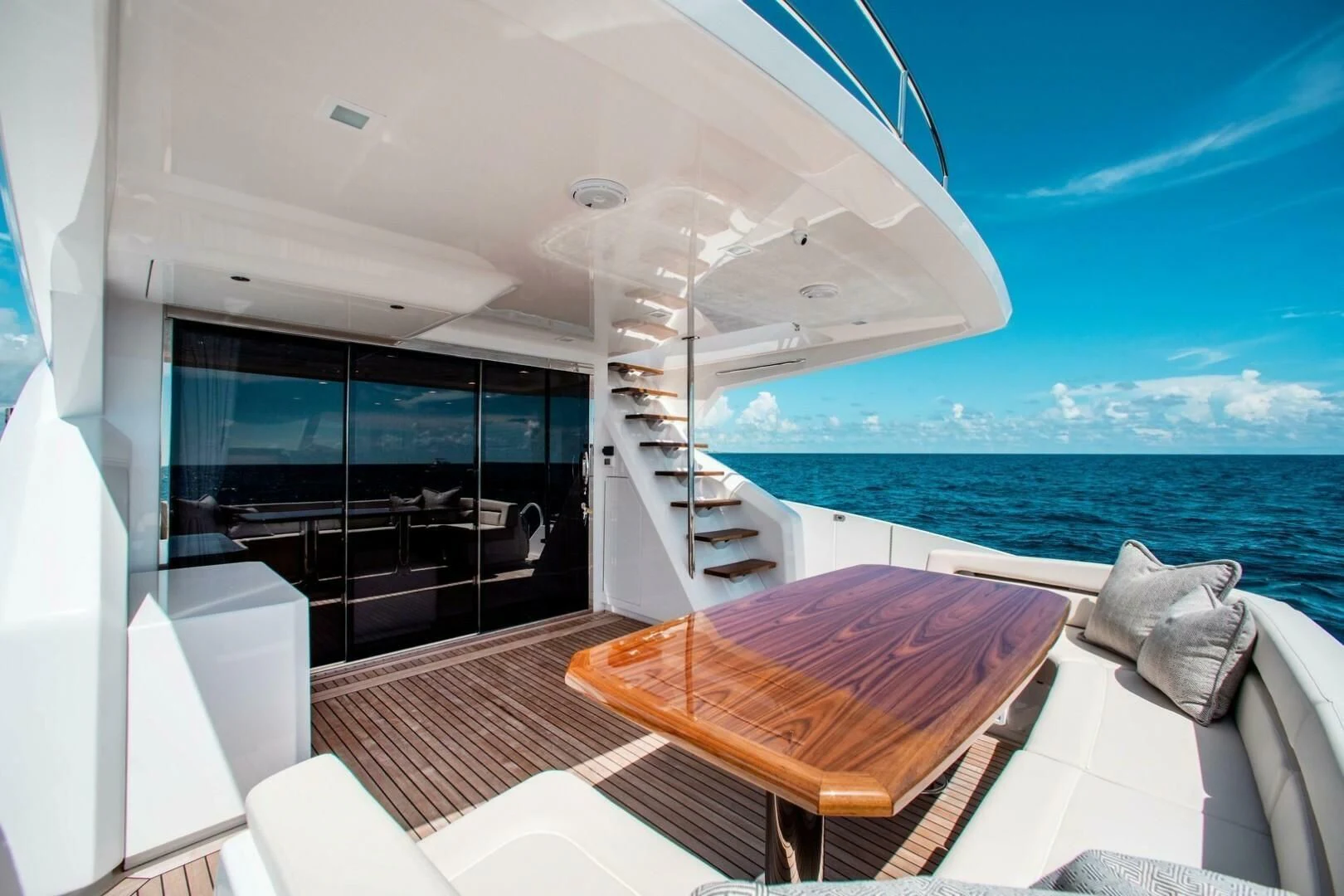a balcony with a table and chairs aboard MANA Yacht for Sale