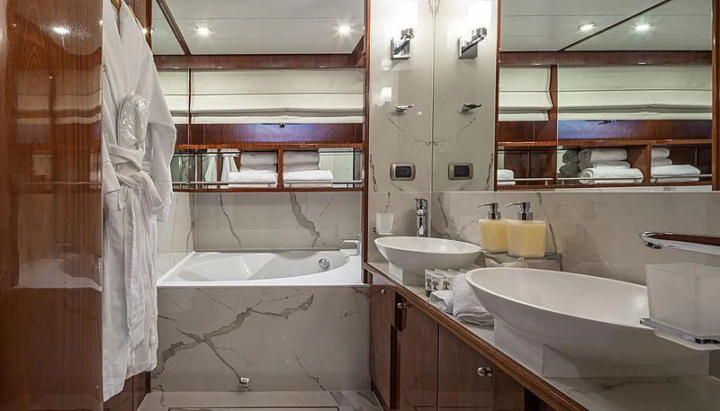 a bathroom with a tub sink and a sink aboard GRACE Yacht for Sale