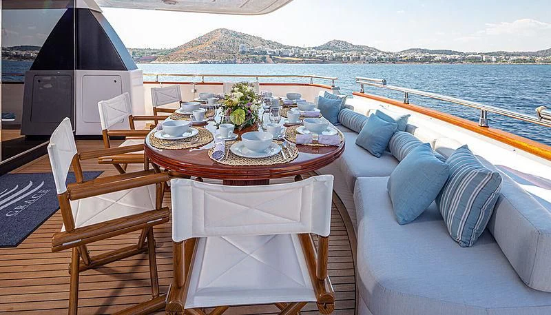 a table with a chair and a couch on a boat aboard GRACE Yacht for Sale
