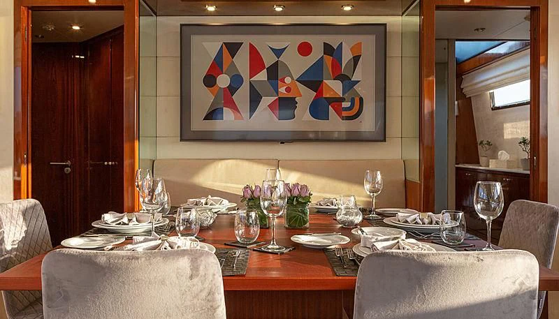a table with wine glasses and plates aboard GRACE Yacht for Sale