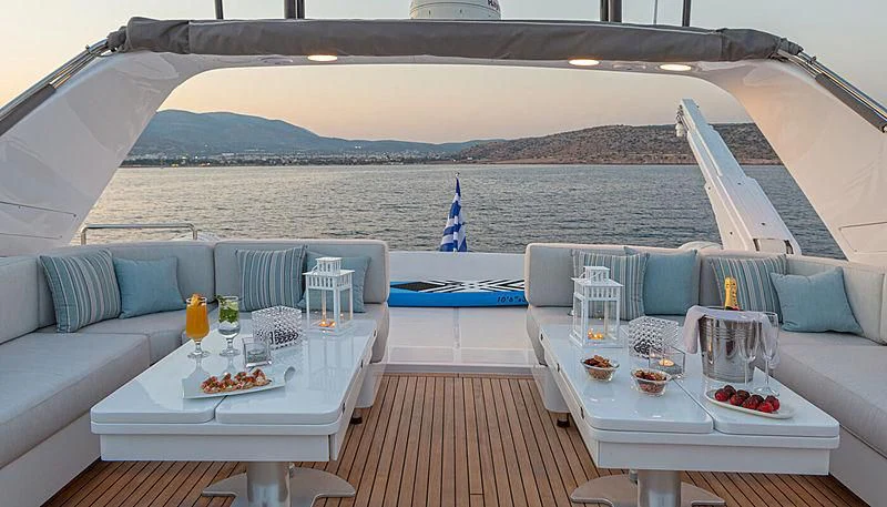 a large white lounge chair with a table and a large white table with food on it aboard GRACE Yacht for Sale